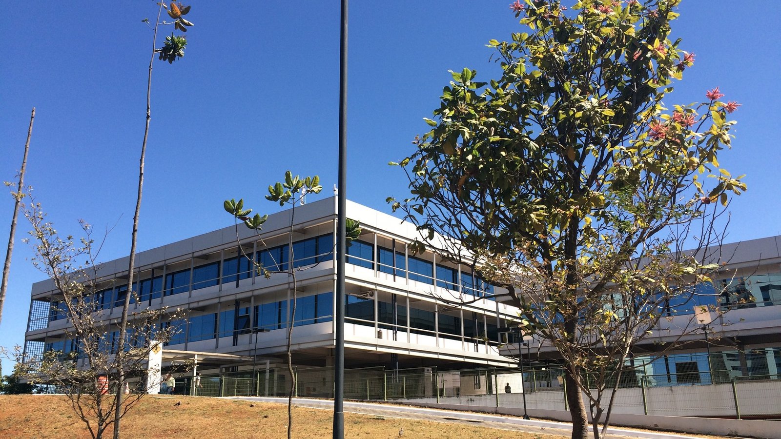 Fachada de vidro e concreto da sede da Caesb, em Brasília, sob céu azul