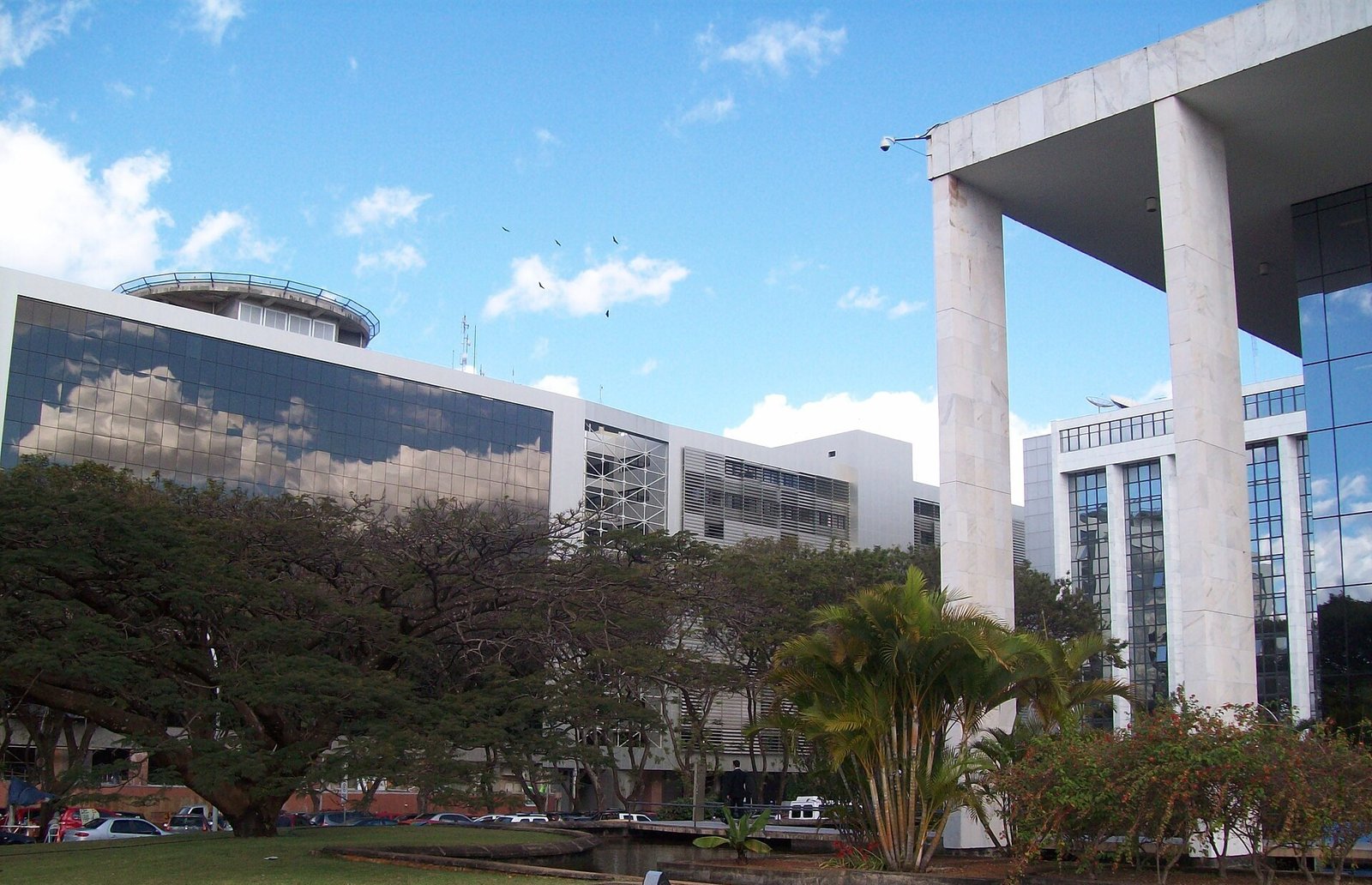 Prédios do complexo judicial de Brasília, com fachadas de vidro e colunas de mármore sob céu azul