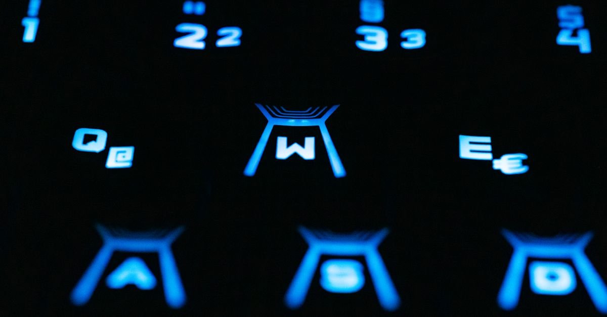 Teclado de computador retroiluminado em azul, com as teclas W, A, S e D em destaque