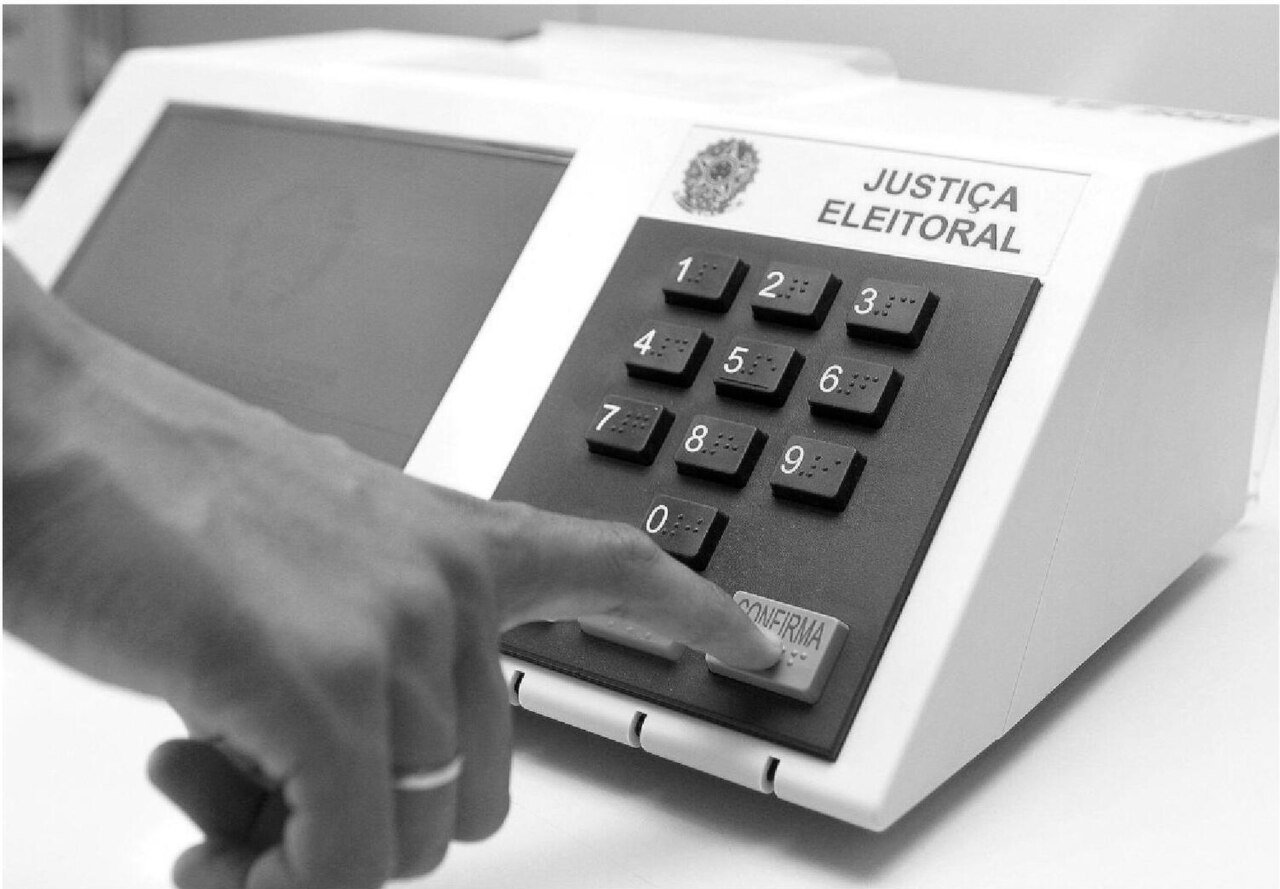 Eleitor pressiona a tecla confirma em urna eletrônica da Justiça Eleitoral