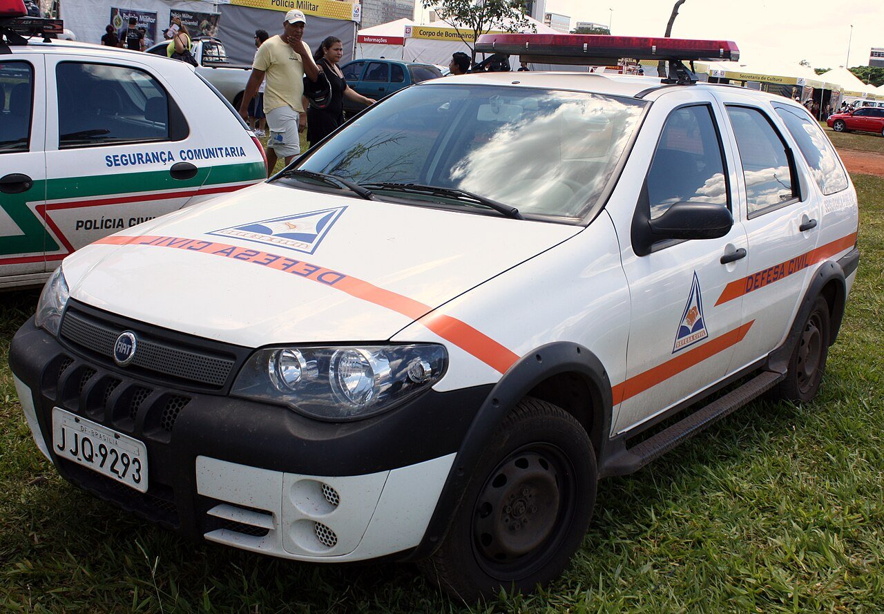 Viatura branca e laranja da Defesa Civil do DF ao lado de carro da Polícia Civil em evento ao ar livre