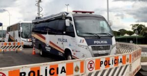 Micro-ônibus da Polícia Militar do DF estacionado atrás de barreiras com a inscrição POLÍCIA