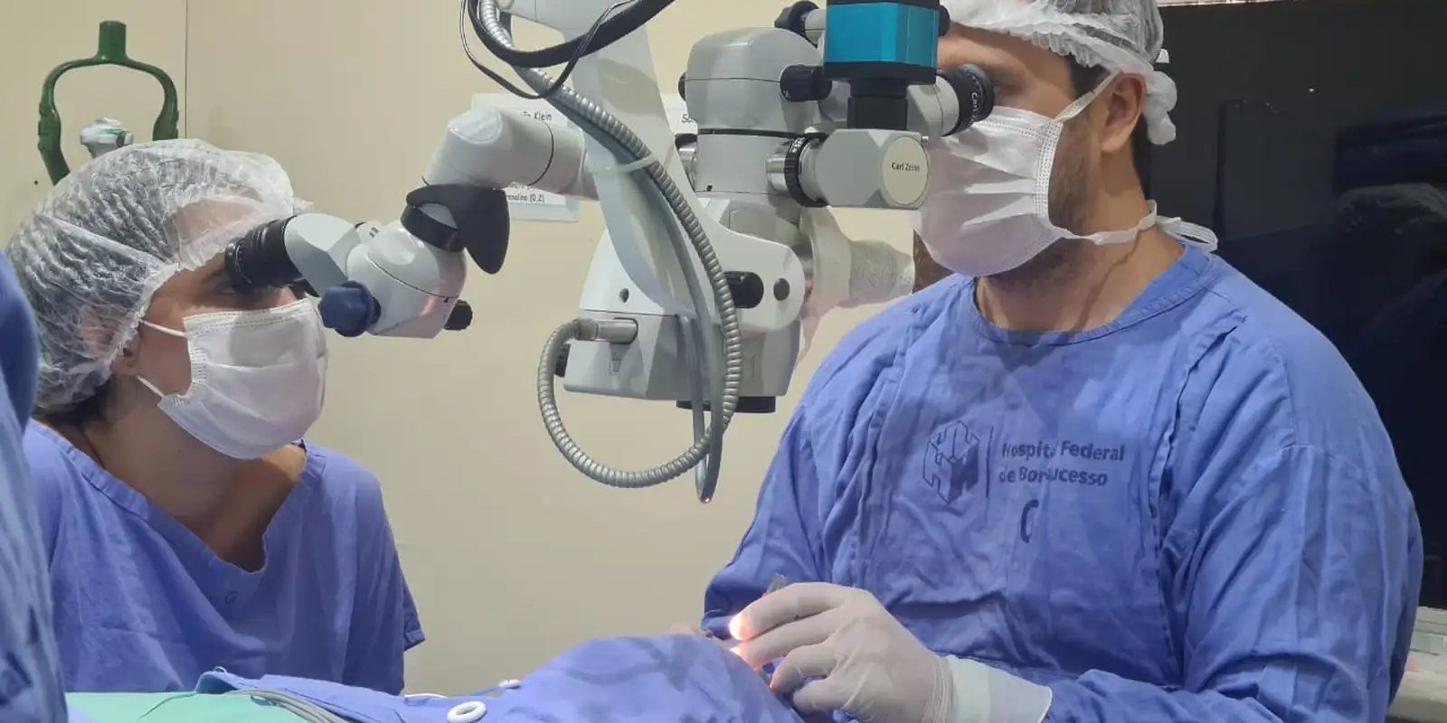 Equipe médica realiza cirurgia oftalmológica com microscópio em hospital público
