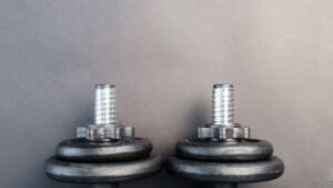 Dois halteres de ferro sobre fundo cinza