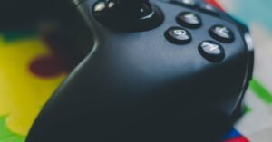 Controle de videogame preto em closeup sobre superfície colorida