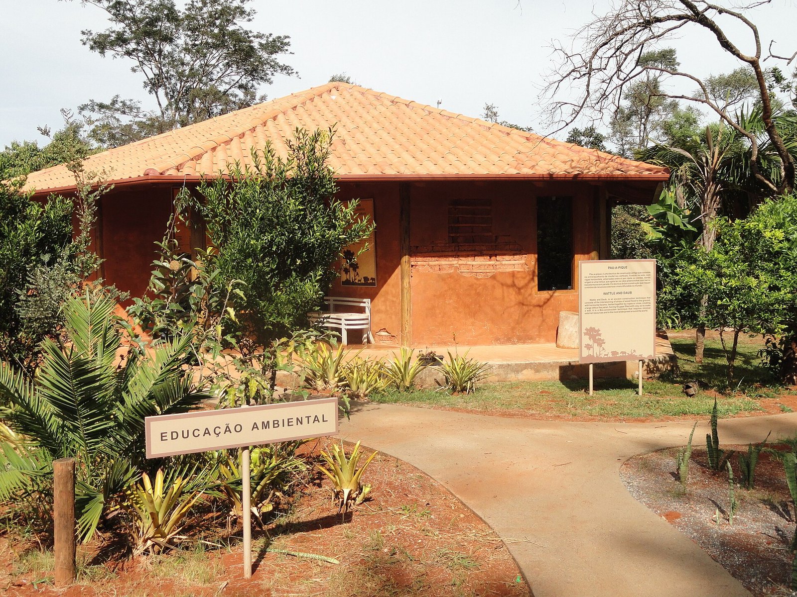 Casa de pau a pique com placa Educação Ambiental no Jardim Botânico de Brasília