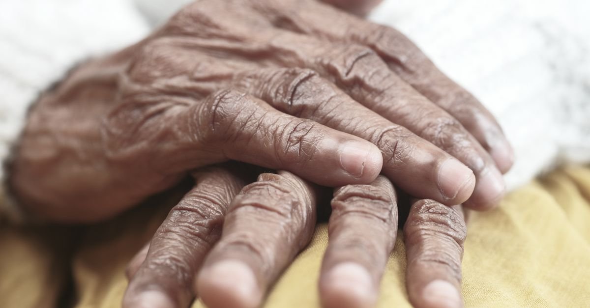 Mãos de uma pessoa idosa, uma sobre a outra, em close-up