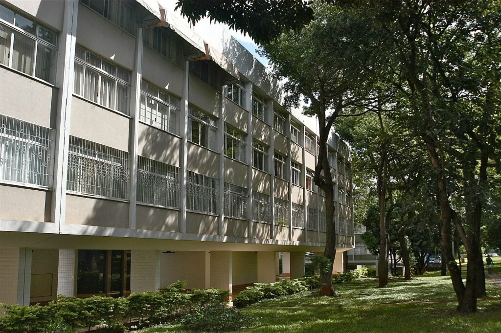 Fachada de bloco residencial sobre pilotis em superquadra de Brasilia, cercado por arvores