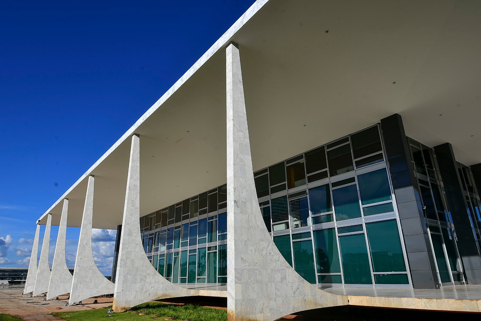 Fachada do Supremo Tribunal Federal, em Brasília, vista de baixo, com as colunas de mármore e o céu azul