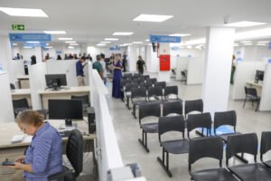 Área de atendimento de unidade do Na Hora no Distrito Federal, com guichês e cadeiras de espera