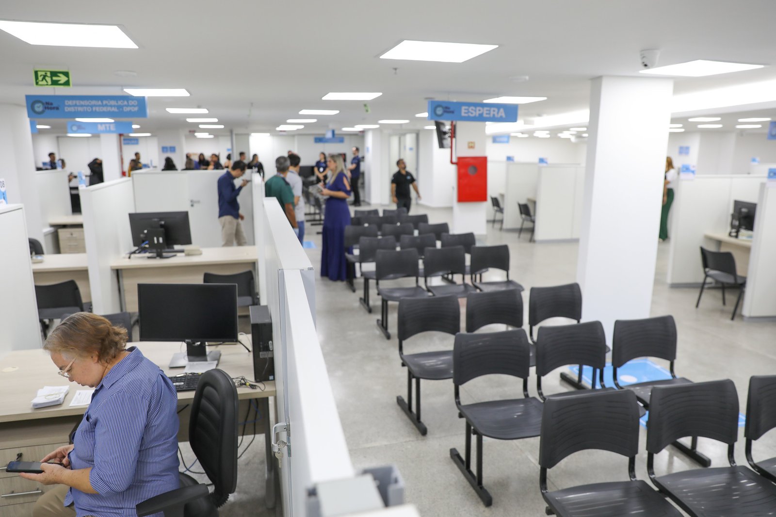 Área de atendimento de unidade do Na Hora no Distrito Federal, com guichês e cadeiras de espera
