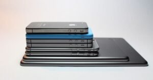 Pilha de celulares e tablets empilhados sobre superfície clara