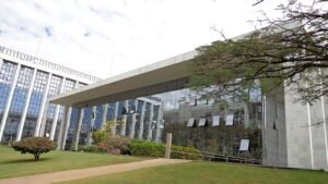 Fachada de vidro e mármore do prédio do Tribunal de Justiça do Distrito Federal e dos Territórios, em Brasília, com jardim à frente