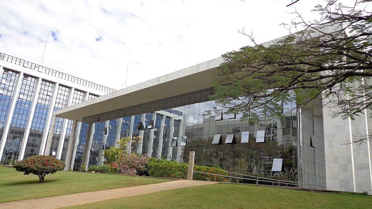 Fachada de vidro e mármore do prédio do Tribunal de Justiça do Distrito Federal e dos Territórios, em Brasília, com jardim à frente