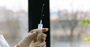 Profissional de saúde segura seringa preparada para aplicação