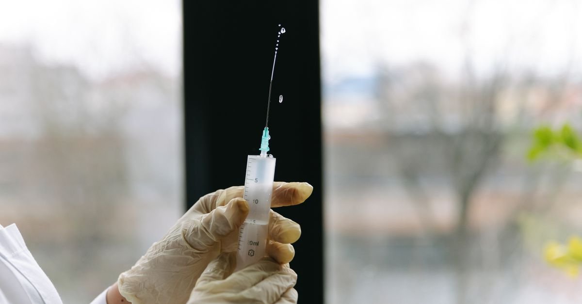 Profissional de saúde segura seringa preparada para aplicação