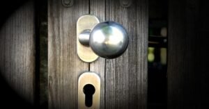 Maçaneta de metal e fechadura em porta de madeira