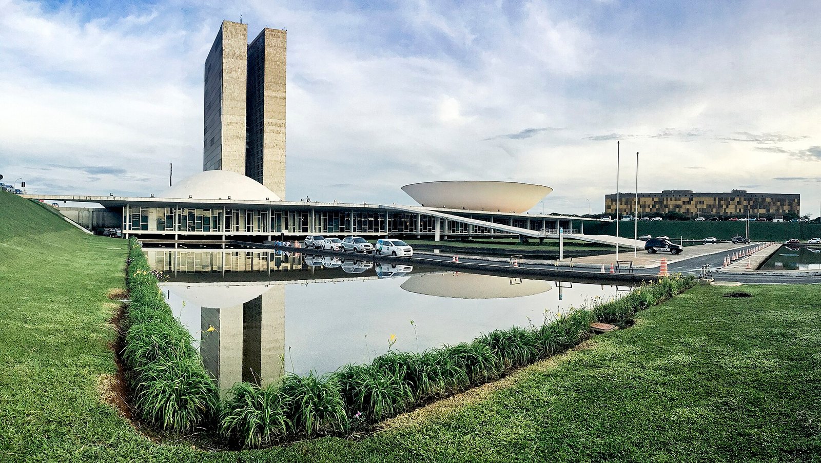 Fachada do Palácio do Congresso Nacional, com as duas torres e as cúpulas da Câmara e do Senado refletidas no espelho d'água