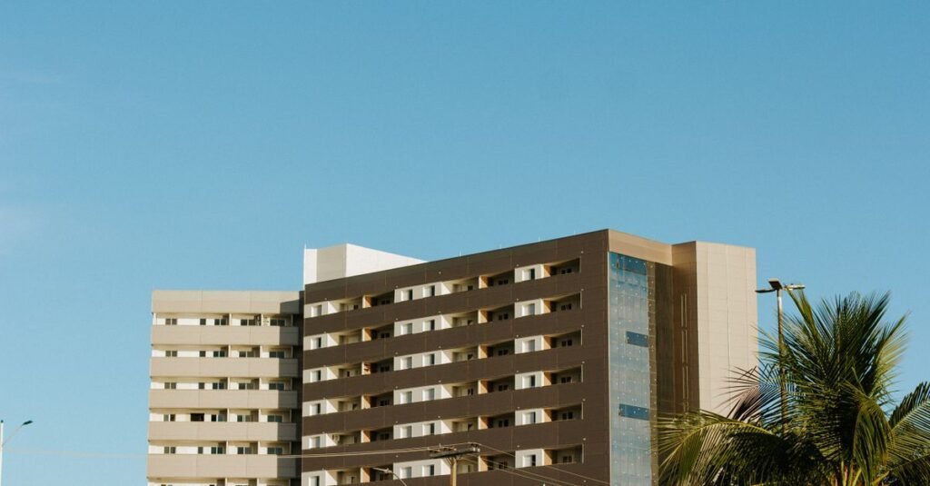 Fachada de prédio residencial em condomínio, vista da rua sob céu azul