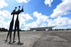 Escultura Os Candangos na Praça dos Três Poderes vazia, com o Palácio do Planalto ao fundo