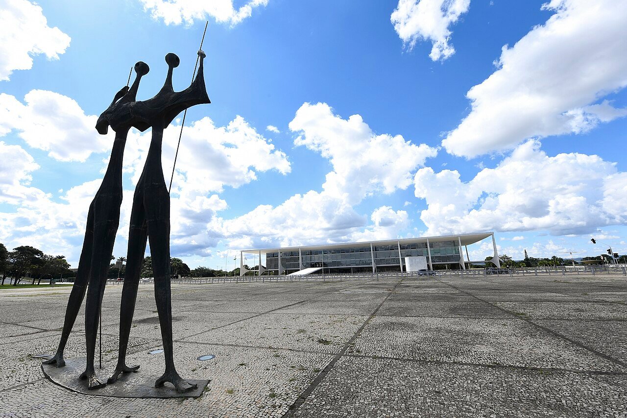 Escultura Os Candangos na Praça dos Três Poderes vazia, com o Palácio do Planalto ao fundo