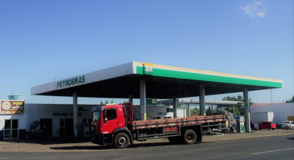 Posto de combustível da bandeira Petrobras BR à beira de rodovia, com bombas e caminhão