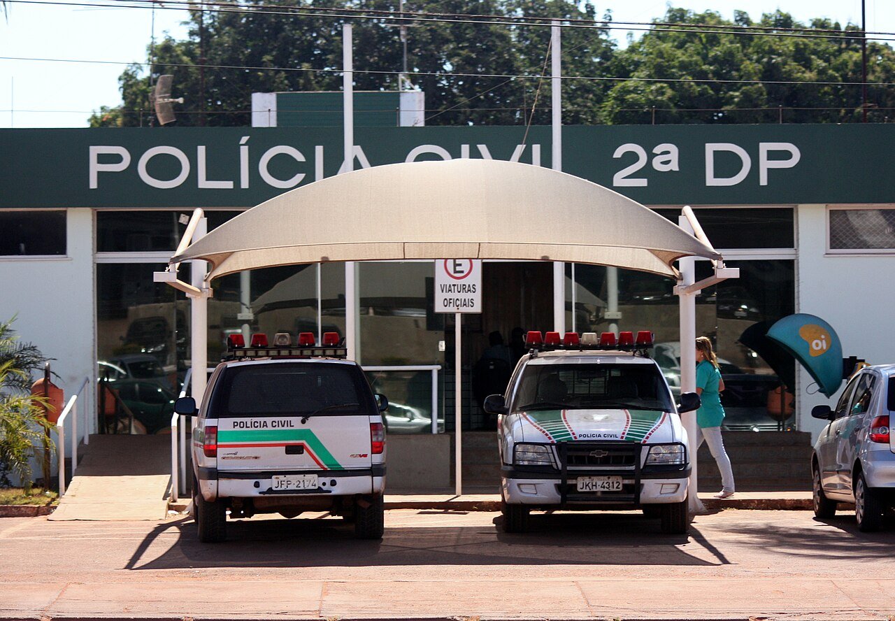 Viaturas da Polícia Civil do Distrito Federal estacionadas em frente à fachada de uma delegacia