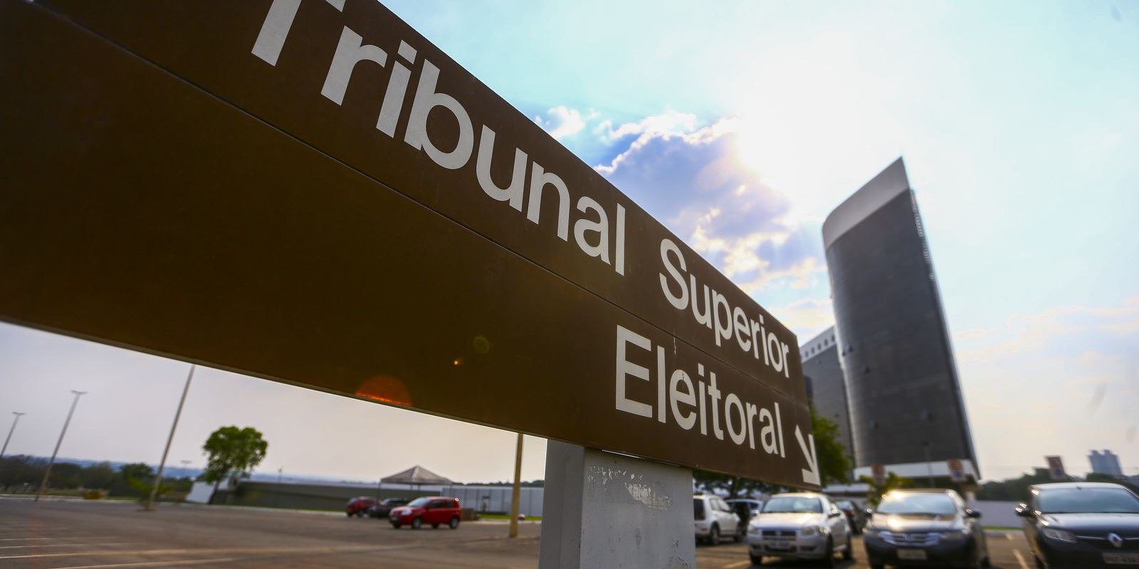 Placa com a inscrição Tribunal Superior Eleitoral e o edifício-sede do TSE ao fundo, em Brasília