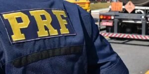 Colete azul com a inscrição PRF em policial rodoviário federal durante fiscalização