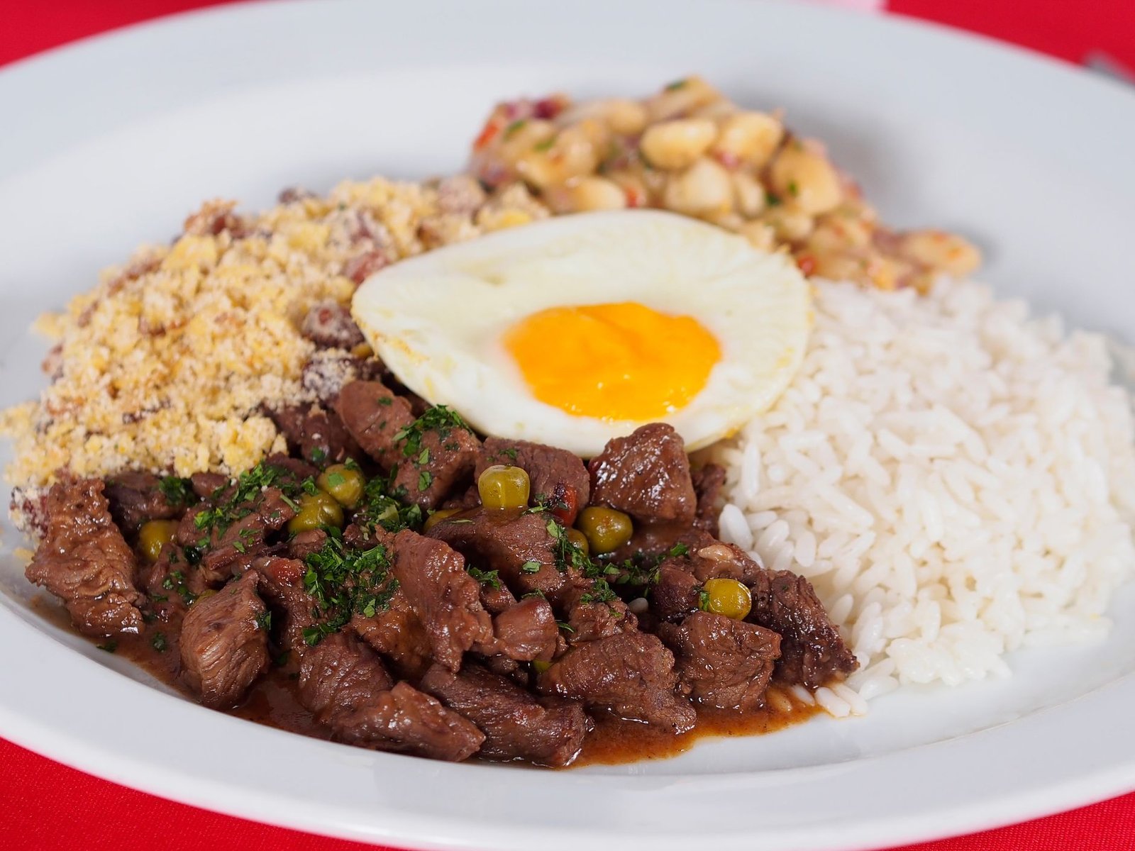 Prato com arroz, feijão, farofa, carne em cubos e ovo frito, refeição típica servida no almoço dos restaurantes comunitários