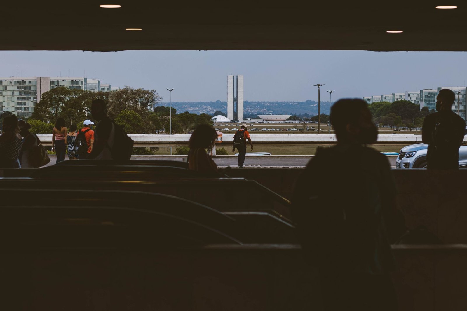 Pessoas caminham na plataforma da rodoviária do Plano Piloto com o Congresso Nacional ao fundo