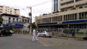 Fachada de agência da Caixa Econômica Federal em rua movimentada