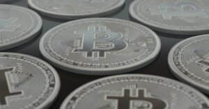 Moedas físicas com o símbolo do bitcoin dispostas lado a lado