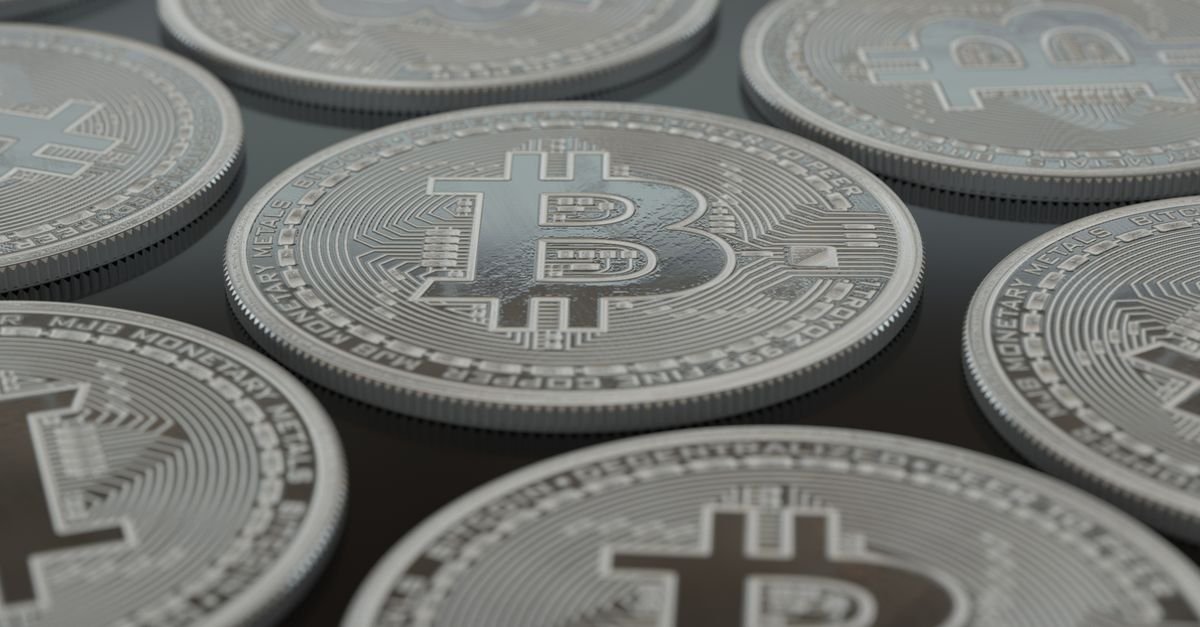 Moedas físicas com o símbolo do bitcoin dispostas lado a lado
