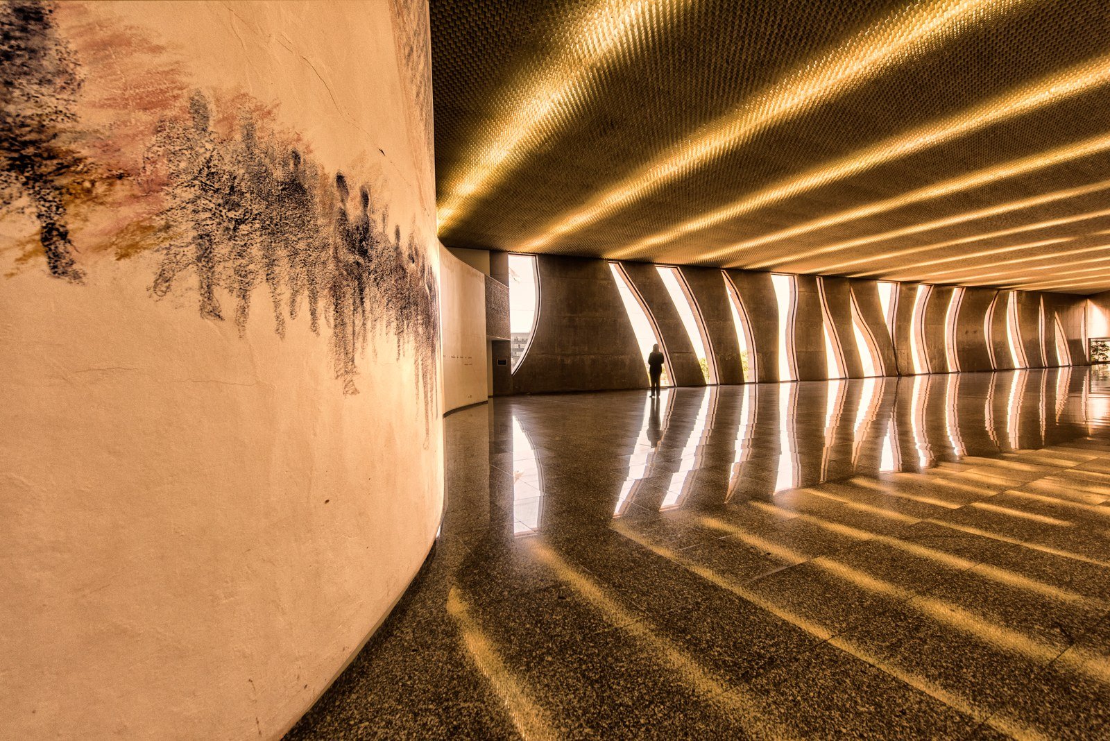 Galeria interna do edifício-sede do Superior Tribunal de Justiça, em Brasília, com colunas curvas e piso espelhado