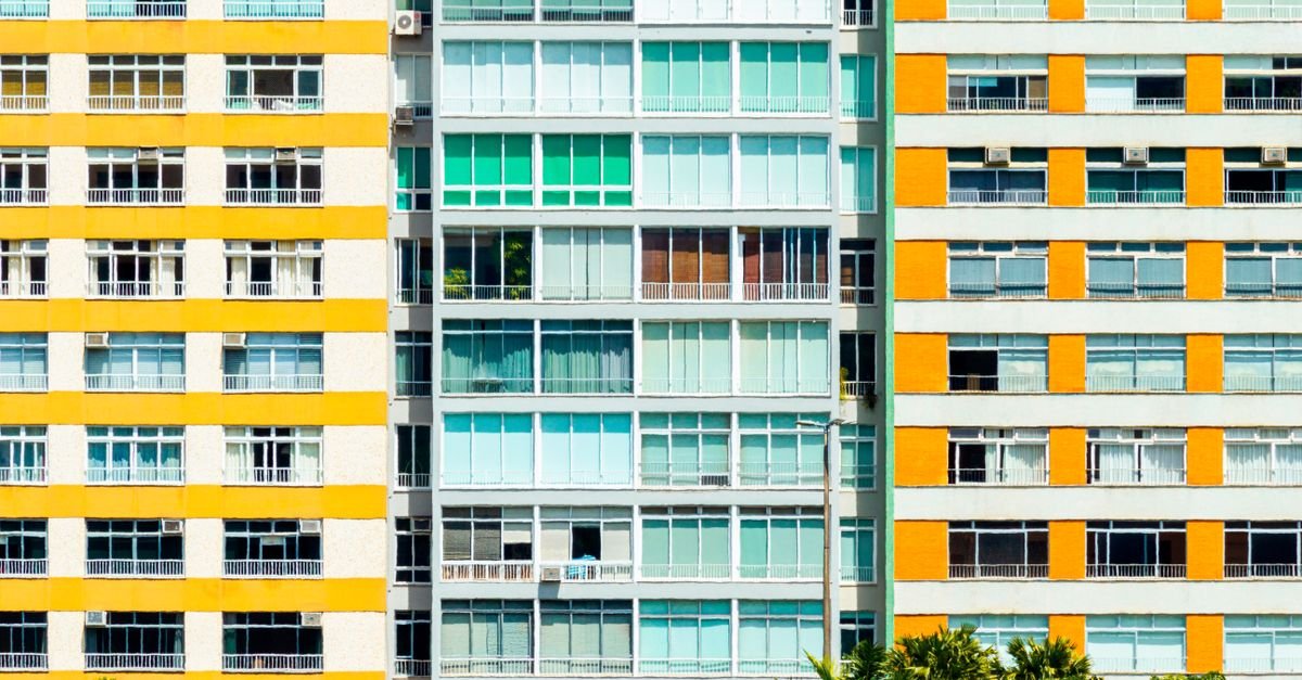 Fachadas coloridas de prédios residenciais com varandas e janelas alinhadas