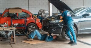 Mecânicos trabalhando em carros dentro de uma oficina