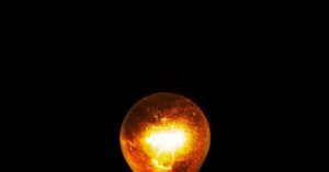 Lâmpada incandescente acesa em fundo escuro