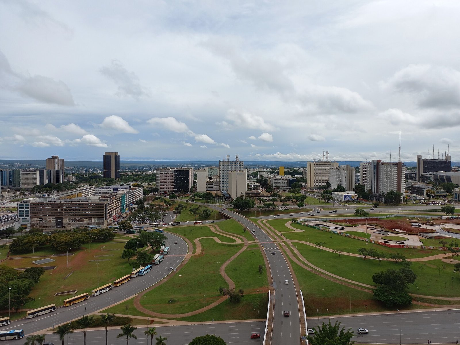 Vista aérea do Eixo Monumental, em Brasília, com carros e ônibus circulando nas pistas do Plano Piloto