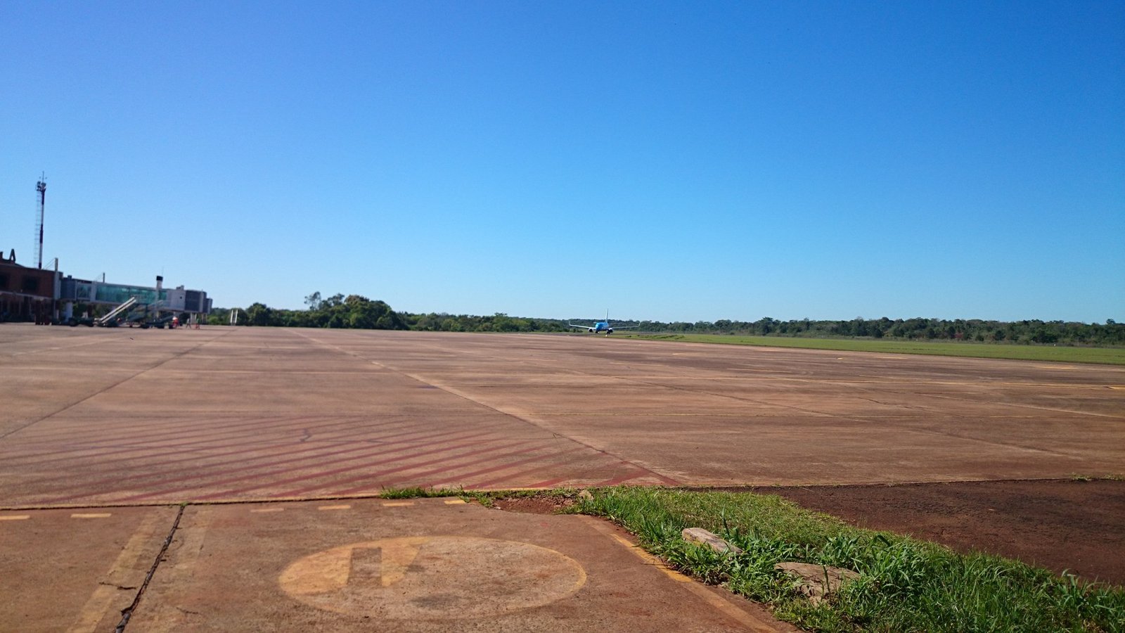 Pátio do aeroporto internacional de Puerto Iguazú, na Argentina, com avião ao fundo, em foto de arquivo