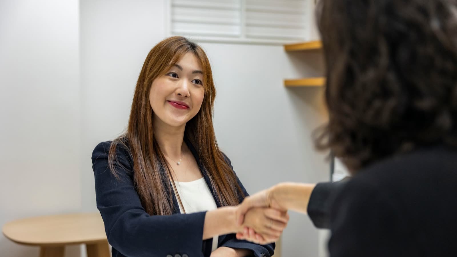 Candidata a vaga de emprego cumprimenta recrutadora em entrevista