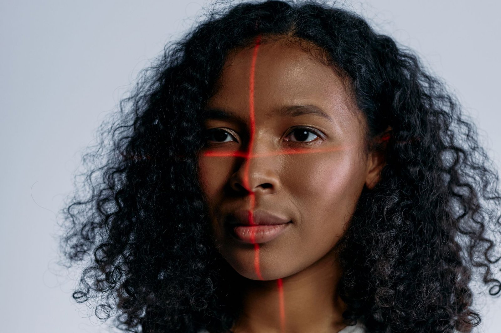 Rosto de mulher com linhas de laser vermelho em simulação de reconhecimento facial