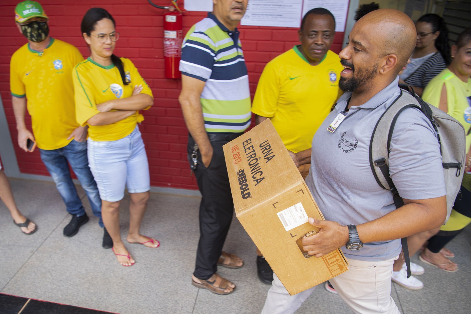 Servidor carrega caixa com urna eletrônica em seção eleitoral, em foto do segundo turno de 2022