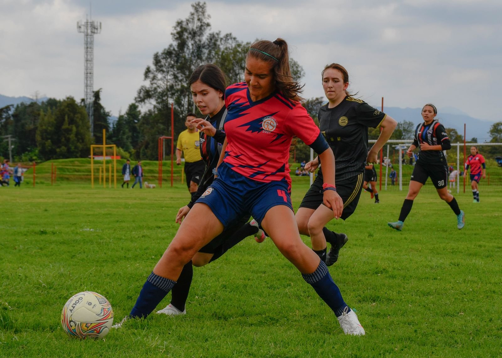 Jogadoras disputam a bola durante partida de futebol feminino em campo gramado (foto ilustrativa)