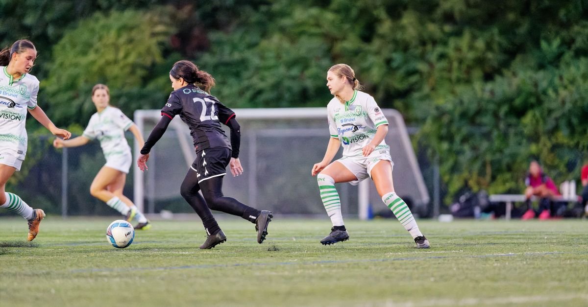 Jogadoras disputam a bola em partida de futebol feminino em campo gramado (foto de arquivo)