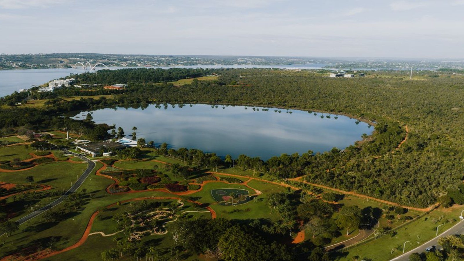Vista aérea de lago cercado de áreas verdes em Brasília