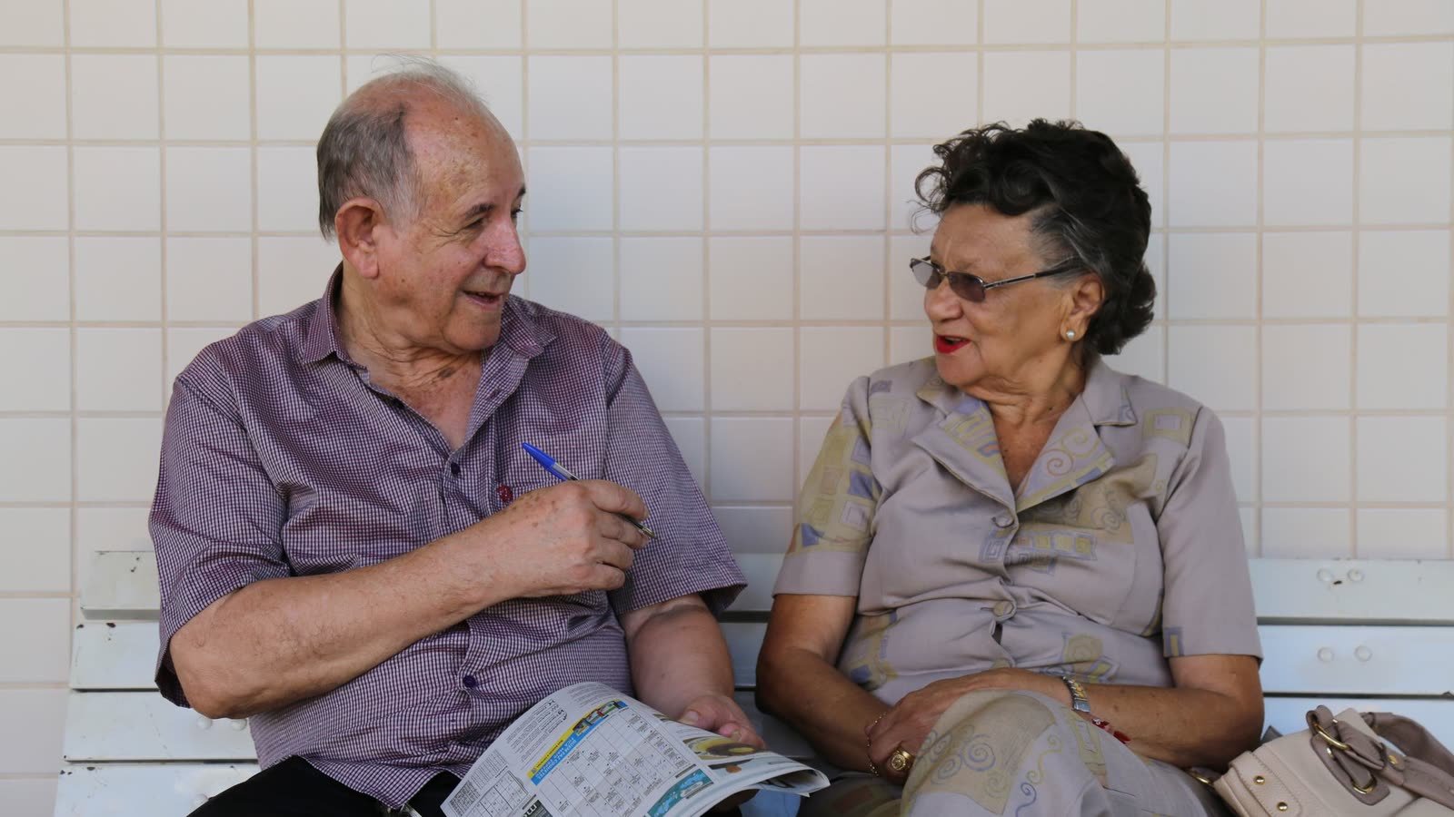 Casal de idosos conversando sentado em um banco em Brasília