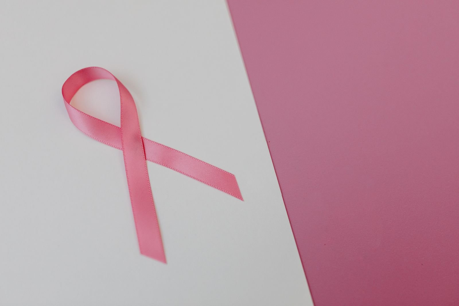 Laço rosa do Outubro Rosa sobre fundo claro e rosa (foto ilustrativa)
