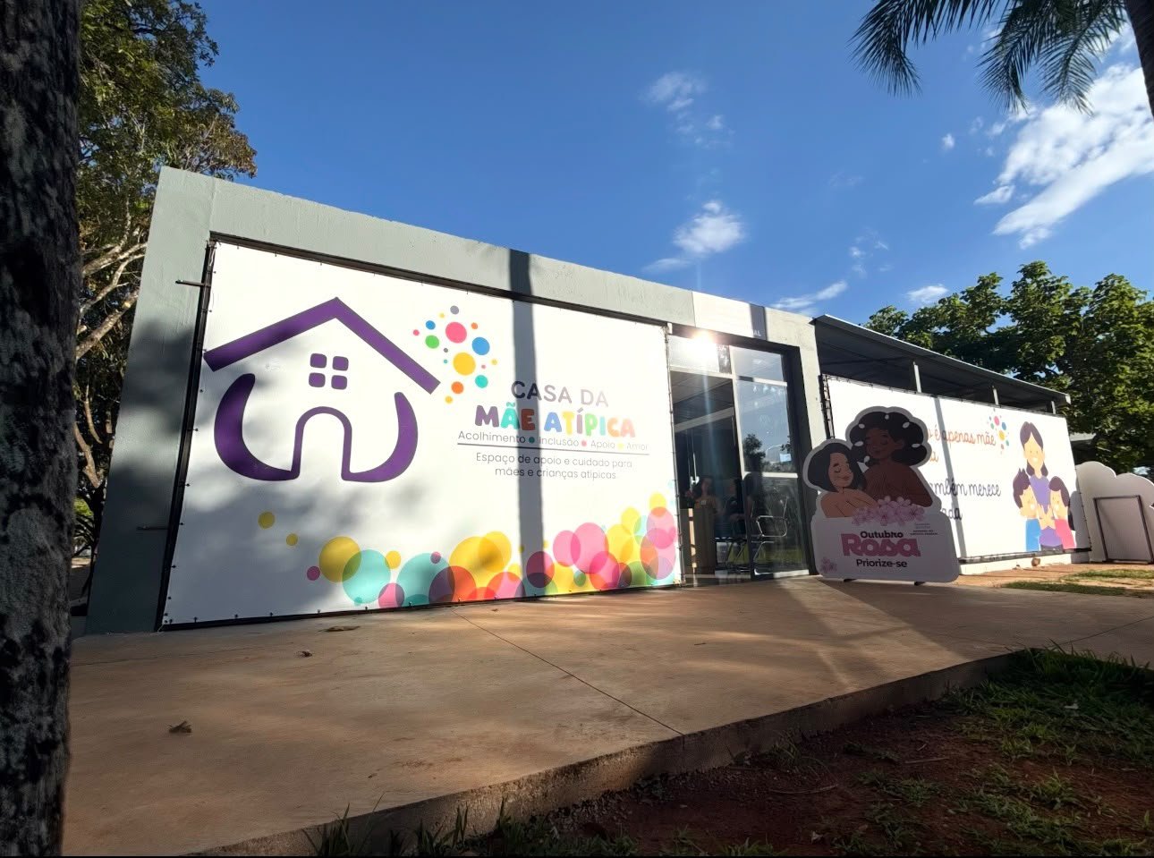 Fachada da Casa da Mãe Atípica, no Parque da Cidade, com faixas coloridas e a identidade visual do espaço