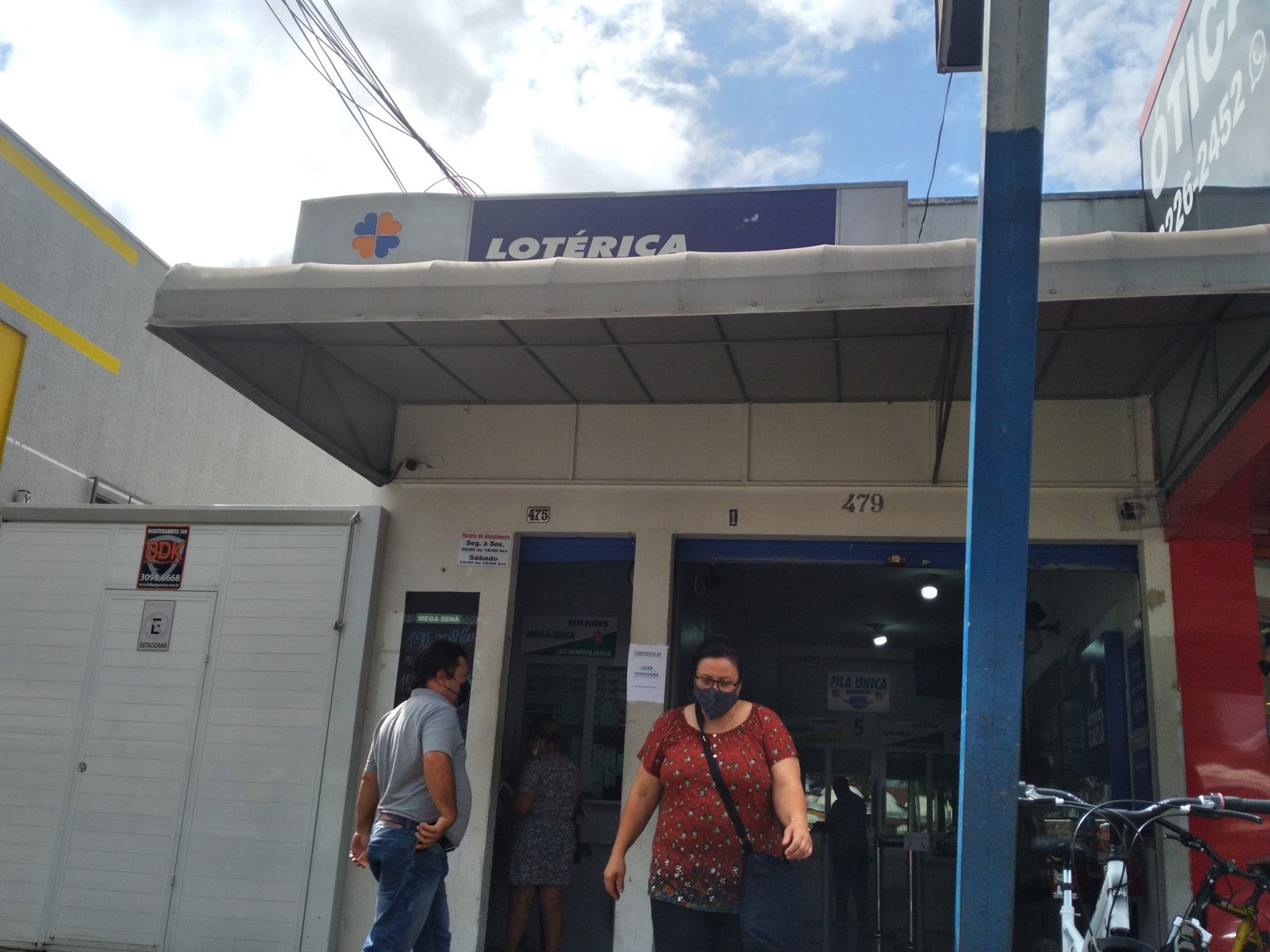 Fachada de casa lotérica com o logotipo da Caixa e clientes na porta, em foto de arquivo feita em Curitiba